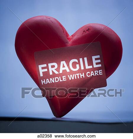 Heart with sign reading fragile View Large Photo Image Stock Photo - Heart with sign reading fragile. Fotosearch