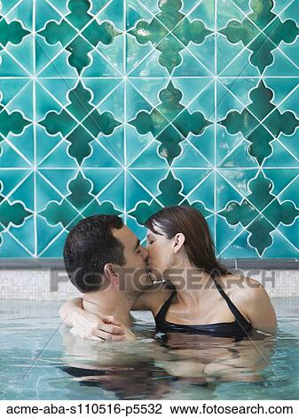 Stock Image - Italy, Amalfi Coast, Ravello, Mature couple kissing in swimming pool. Fotosearch