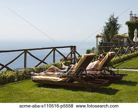Stock Photo - Italy, Amalfi Coast, Ravello, Mature couple lying on lounge chairs. Fotosearch