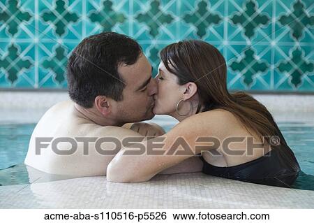 Stock Photograph - Italy, Amalfi Coast, Ravello, Mature couple kissing in swimming pool. Fotosearch