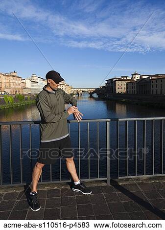 Italy, Florence, Man checking time on bridge over River Arno View Large Photo Image Stock Image - Italy, Florence, Man checking time on bridge over River Arno . Fotosearch