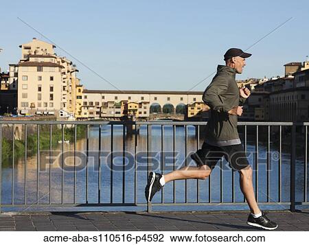 Italy, Florence, Man jogging past Ponte Vecchio over River Arno View Large Photo Image Stock Image - Italy, Florence, Man jogging past Ponte Vecchio over River Arno . Fotosearch