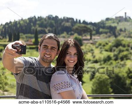 Italy, Florence, Young couple photographing themselves in rural area View Large Photo Image Stock Photograph - Italy, Florence, Young couple photographing themselves in rural area. Fotosearch