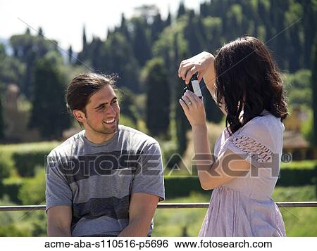 Italy, Florence, Young man leaning against fence while woman is taking photograph View Large Photo Image Stock Photograph - Italy, Florence, Young man leaning against fence while woman is taking photograph. Fotosearch