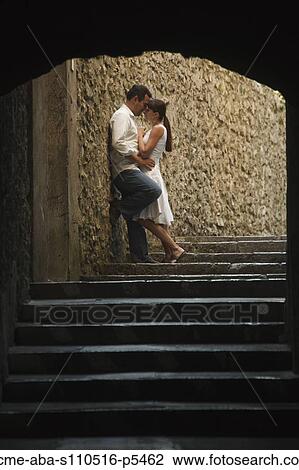 Stock Image - Italy, Ravello, Mature couple kissing in archway. Fotosearch