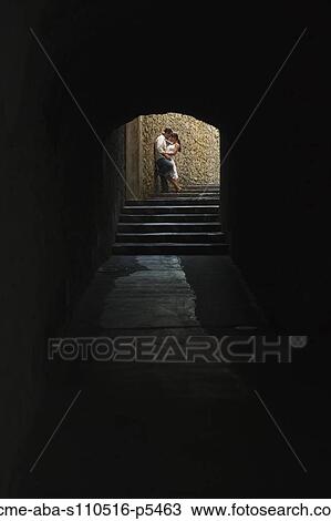 Stock Image - Italy, Ravello, Mature couple kissing in archway. Fotosearch