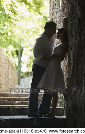 Stock Image - Italy, Ravello, Mature couple kissing in narrow lane. Fotosearch
