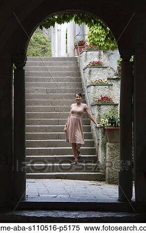 Stock Photography - Italy, Ravello, Portrait of woman in dress standing on stairs. Fotosearch