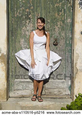 Italy, Ravello, Portrait of woman standing in front of watered wooden door, wind blowing woman's dress View Large Photo Image Stock Photograph - Italy, Ravello, Portrait of woman standing in front of watered wooden door, wind blowing woman's dress. Fotosearch