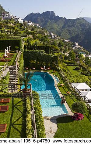 Stock Image - Italy, Ravello, Terrace with outdoor pool and couple kissing. Fotosearch
