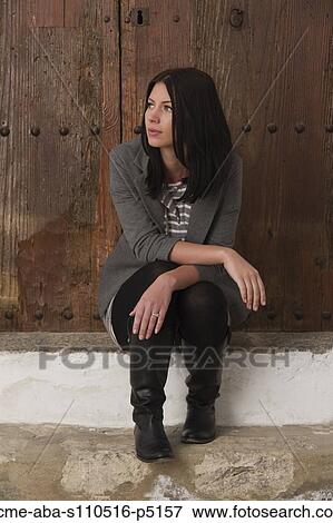 Stock Photo - Italy, Ravello, Young woman sitting and looking away. Fotosearch