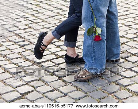 Italy, Rome, Vatican City, Close up of legs of couple with rose standing on cobblestone View Large Photo Image Stock Photo - Italy, Rome, Vatican City, Close up of legs of couple with rose standing on cobblestone . Fotosearch