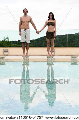 Italy, Tuscany, Couple standing on edge of swimming pool and holding hands View Large Photo Image Stock Photo - Italy, Tuscany, Couple standing on edge of swimming pool and holding hands. Fotosearch