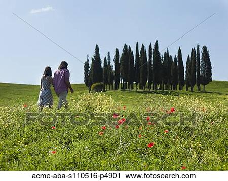 Italy, Tuscany, Val D'Orcia, Couple walking in meadow View Large Photo Image Stock Image - Italy, Tuscany, Val D'Orcia, Couple walking in meadow. Fotosearch