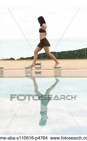 Italy, Tuscany, Woman balancing on edge of swimming pool View Large Photo Image Picture - Italy, Tuscany, Woman balancing on edge of swimming pool. Fotosearch