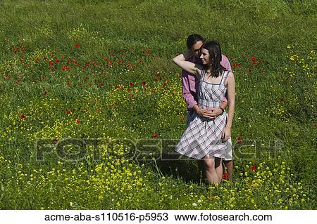 Italy, Tuscany, Young couple embracing on meadow View Large Photo Image Stock Image - Italy, Tuscany, Young couple embracing on meadow. Fotosearch