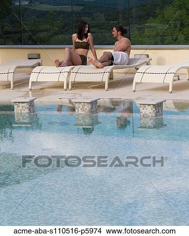 Italy, Tuscany, Young couple relaxing by pool View Large Photo Image Picture - Italy, Tuscany, Young couple relaxing by pool. Fotosearch