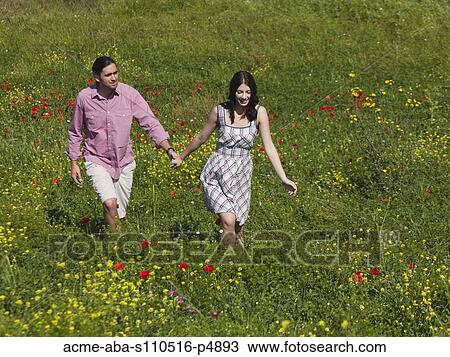 Italy, Tuscany, Young couple walking on meadow View Large Photo Image Stock Image - Italy, Tuscany, Young couple walking on meadow. Fotosearch