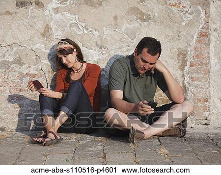 Italy, Venice, Couple text messaging by wall View Large Photo Image Stock Image - Italy, Venice, Couple text messaging by wall. Fotosearch