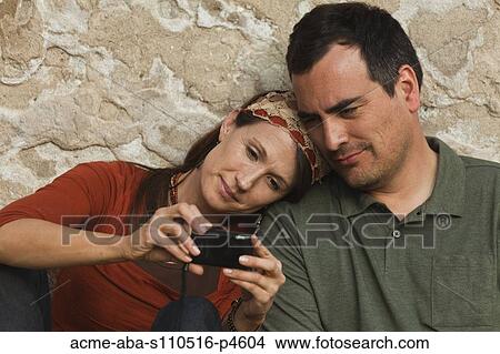 Italy, Venice, Couple viewing digital camera by wall View Large Photo Image Picture - Italy, Venice, Couple viewing digital camera by wall. Fotosearch