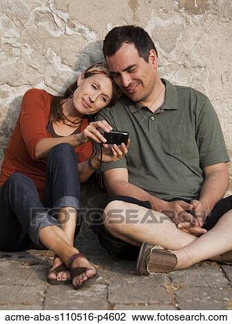 Italy, Venice, Couple viewing digital camera by wall View Large Photo Image Stock Image - Italy, Venice, Couple viewing digital camera by wall. Fotosearch