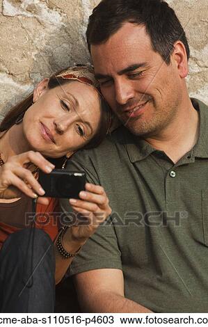Italy, Venice, Couple viewing digital camera by wall View Large Photo Image Stock Image - Italy, Venice, Couple viewing digital camera by wall. Fotosearch