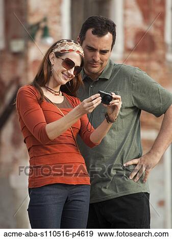 Italy, Venice, Couple viewing digital camera in city View Large Photo Image Stock Photo - Italy, Venice, Couple viewing digital camera in city. Fotosearch