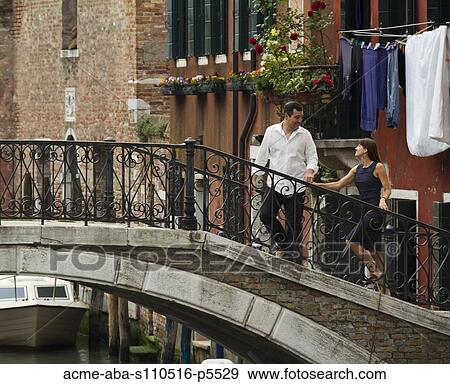 Italy, Venice, Mature couple holding hands and walking through bridge View Large Photo Image Stock Photo - Italy, Venice, Mature couple holding hands and walking through bridge. Fotosearch