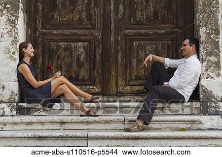 Italy, Venice, Mature couple sitting at steps, woman holding single red rose View Large Photo Image Picture - Italy, Venice, Mature couple sitting at steps, woman holding single red rose. Fotosearch
