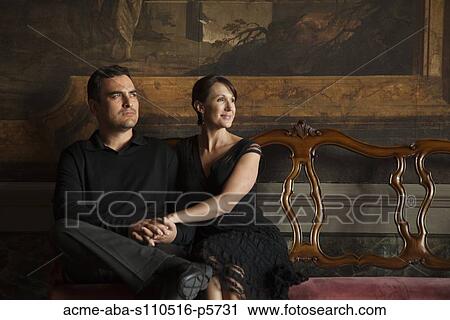 Stock Image - Italy, Venice, Mature couple sitting in museum hall. Fotosearch