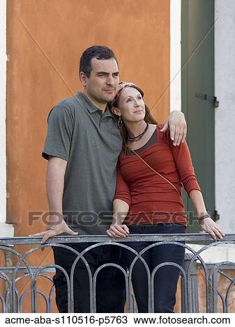Stock Image - Italy, Venice, Mature couple standing on balcony. Fotosearch