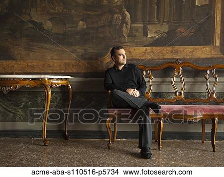 Picture - Italy, Venice, Mature man sitting in museum hall. Fotosearch