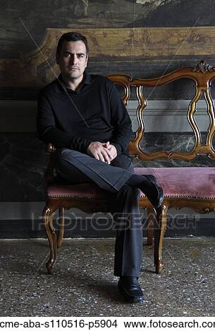 Italy, Venice, Portrait of man sitting on old chair View Large Photo Image Picture - Italy, Venice, Portrait of man sitting on old chair. Fotosearch