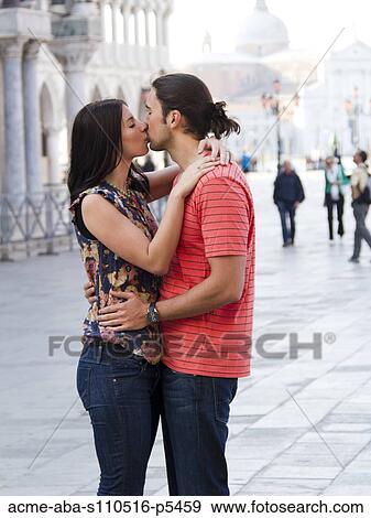 Stock Photo - Italy, Venice, Young couple kissing in street. Fotosearch