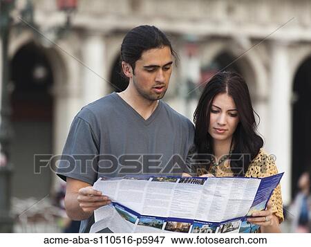 Stock Photo - Italy, Venice, Young couple looking at map on St. Mark's Square. Fotosearch