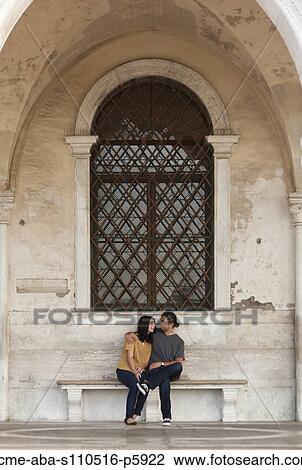 Italy, Venice, Young couple sitting on old bench View Large Photo Image Stock Image - Italy, Venice, Young couple sitting on old bench. Fotosearch