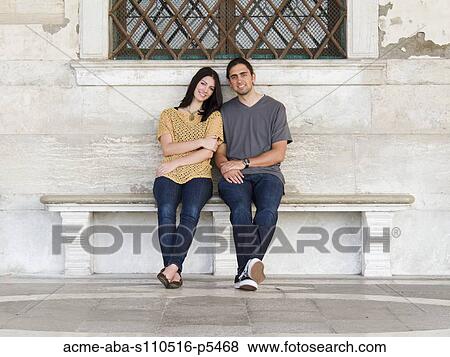 Italy, Venice, Young couple sitting on bench outside historic building View Large Photo Image Stock Photo - Italy, Venice, Young couple sitting on bench outside historic building. Fotosearch