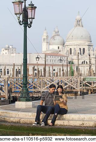 Italy, Venice, Young couple using digital tablet, Santa Maria Della Salute church in background View Large Photo Image Stock Image - Italy, Venice, Young couple using digital tablet, Santa Maria Della Salute church in background. Fotosearch