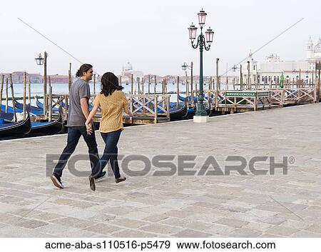 Stock Photo - Italy, Venice, Young couple walking along canal. Fotosearch