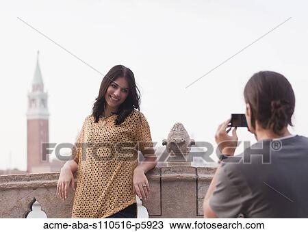 Italy, Venice, Young man photographing woman on bridge San Giorgio Maggiore church in background View Large Photo Image Stock Image - Italy, Venice, Young man photographing woman on bridge San Giorgio Maggiore church in background. Fotosearch