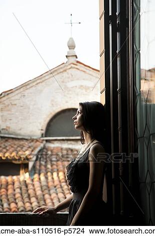 Italy, Venice, Young woman standing in balcony door, contemplating view View Large Photo Image Picture - Italy, Venice, Young woman standing in balcony door, contemplating view. Fotosearch