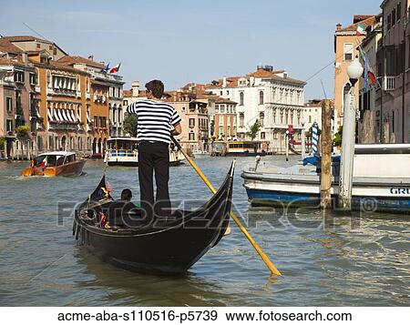 Stock Photo - Italy, Venice, Young woman traveling in gondola on canal. Fotosearch