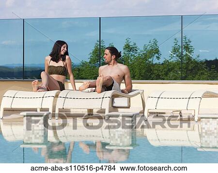 Italy, Young couple relaxing by swimming pool View Large Photo Image Picture - Italy, Young couple relaxing by swimming pool. Fotosearch