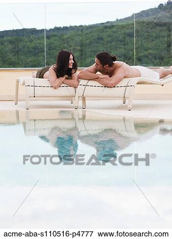 Italy, Young couple relaxing by swimming pool View Large Photo Image Stock Photo - Italy, Young couple relaxing by swimming pool. Fotosearch
