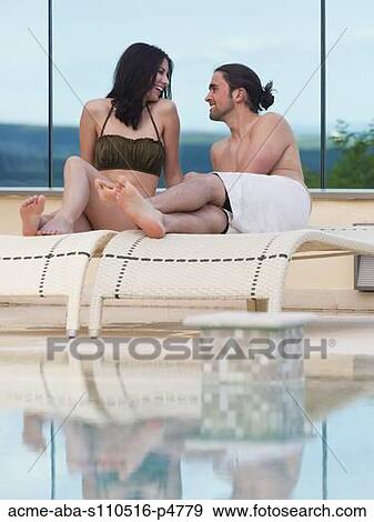 Italy, Young couple relaxing by swimming pool View Large Photo Image Stock Photo - Italy, Young couple relaxing by swimming pool. Fotosearch