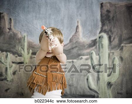 Stock Image - little boy pretending to be cowboy. Fotosearch