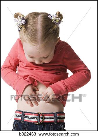 Stock Image - little girl looking at her stomach. Fotosearch