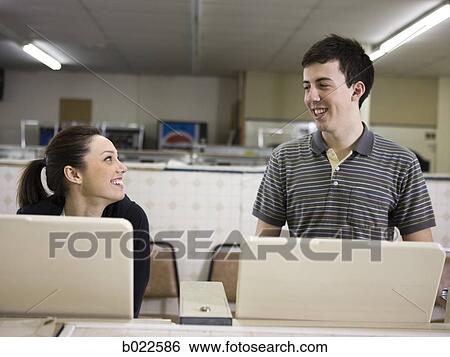 Stock Photograph - man and woman at a laundromat. Fotosearch