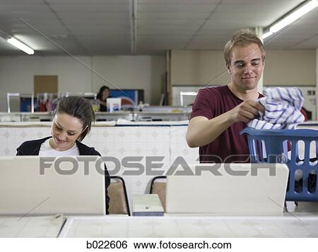 Stock Photograph - man and woman at a laundromat. Fotosearch