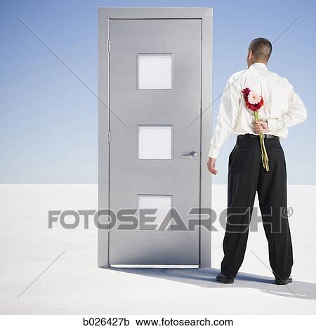 man at a doorway with a flower behind his back View Large Photo Image Stock Image - man at a doorway with a flower behind his back. Fotosearch